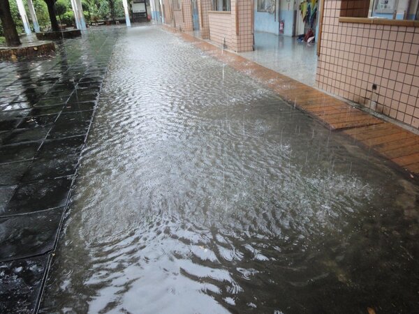 新屋區笨港國小在大雨來襲時，學校通道成了小河。圖／桃園市政府教育局提供