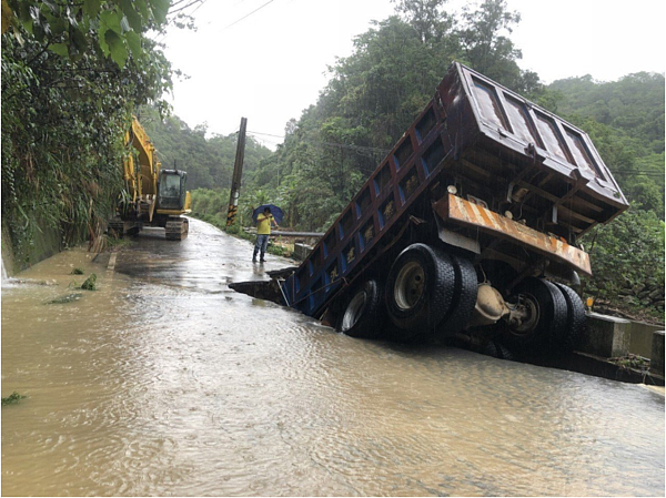 南投縣埔里鎮向善里傳路基淘空，有砂石車因此陷落，幸車上駕駛及時逃亡，無人傷亡。圖／南投縣政府提供