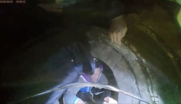 警方見施工人員背陳女欲爬出，趕緊將2人從洞中拉起。記者柯毓庭／翻攝