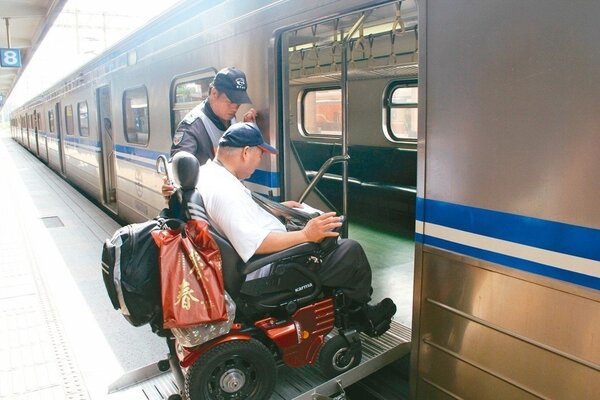 台鐵5月17日起在網頁版訂票頁面新增輪椅座訂票區，更便民。圖為台鐵人員協助輪椅人士上車。 聯合報資料照片