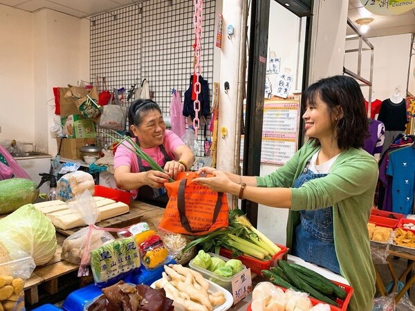 新北蘆洲永平市場部分攤商鼓勵消費者減塑，自備購物袋可享有優惠。圖／環保局提供