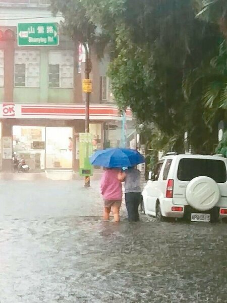 桃園龜山昨天上午瞬間豪雨，包括林口A8、興業街一帶再度淹水，積水最深達30公分淹至小腿肚，行人捲起褲管涉水行走。 圖／警方提供