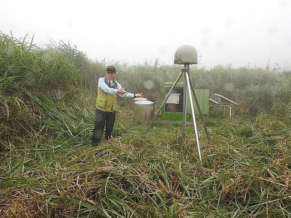 林正洪研究員與小油坑的地球物理監測儀器,由左至右為井下傾斜儀、地震儀及GPS接收器(圓頂),全方面監控火山活動。(圖/科技部提供)