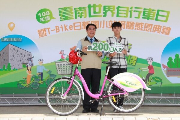 台南市長黃偉哲（左）頒贈一輛T-Bike特仕車給第200萬人次租借人陳嘉謙。圖/交通局提供