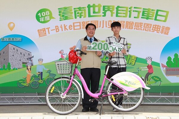 台南市長黃偉哲(左)頒贈一輛T-Bike特仕車給第200萬人次租借人陳嘉謙。圖/交通局提供