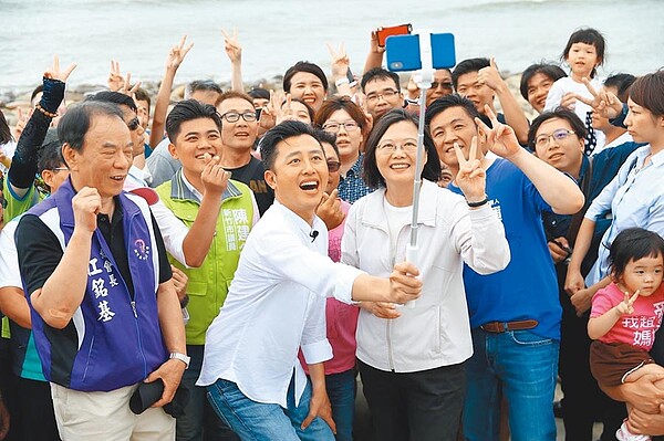 蔡英文總統（中）9日到新竹漁港參訪，與市長林智堅（前左二）等在網紅景點大玩自拍。（徐養齡攝）