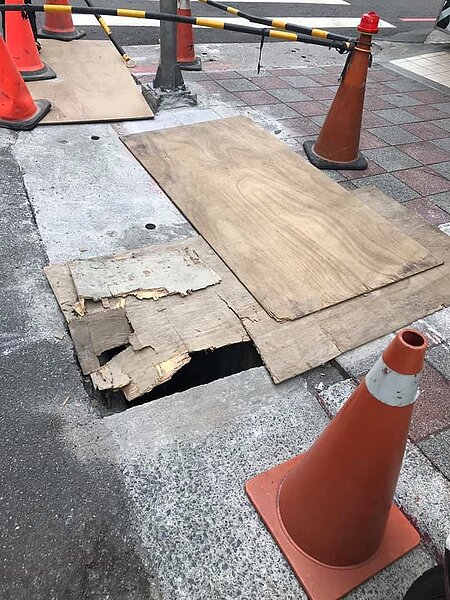 北市內湖區文德路3號前人行道近來有市府外包廠商施作纜線下地工程,在人行道挖出一個約成人肩膀寬的洞,卻只用薄木板遮蓋,被議員李明賢批評是設陷阱。圖/李明賢提供