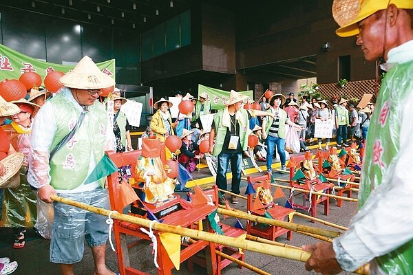 「社子島自救會」成員昨天上午扛著10尊土地公神像，到台北市政府門口請願。 記者徐兆玄／攝影