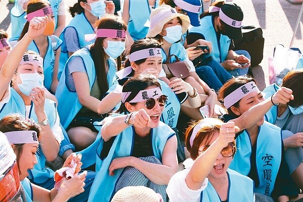 約千名長榮空服員昨在桃園南崁長榮航運大樓前靜坐,綁起粉紅布條、穿上工會背心,將靜坐到罷工結束,還一度與長榮其他員工發生推擠。 記者陳柏亨/攝影