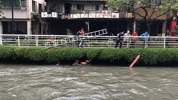 高雄市環保局葉姓、張姓人員今早11點多於幸福川搭乘竹筏清垃圾時，因上午的滂沱雨勢導致水位上升，2人搭乘的船翻覆。記者邱奕能／翻攝