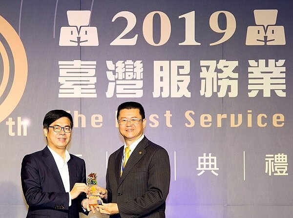 永慶房屋連續七年獲頒「臺灣服務業大評鑑」連鎖房仲第一名!永慶房產集團業務總經理葉凌棋(圖右)從行政院長副院長陳其邁(圖左)手中接獲七連霸獎盃。(圖/永慶房屋)