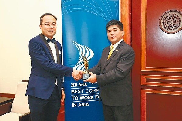 永慶房屋總經理吳良治(右)從BMI集團總編輯吳恩明(左)中接過獎座,連續2年獲頒最佳企業雇主獎,房仲唯一。(永慶房屋提供)