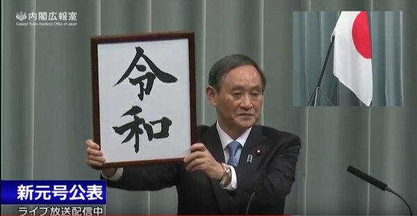 日本官房長官菅義偉舉起新年號圖版，宣告新年號「令和」將到來。（圖翻攝自日內閣直播）