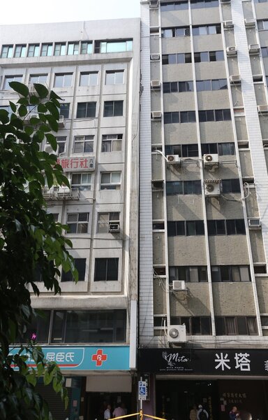 地震造成北市長安東路二段大樓傾斜，77號大樓往右壓著隔壁大樓，造成兩棟間距消失。記者許正宏／攝影 