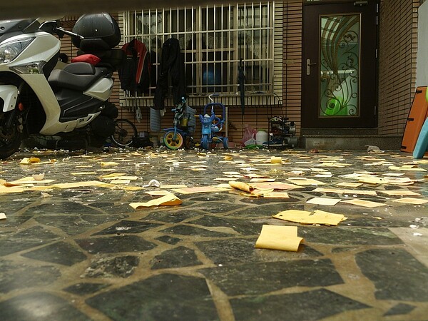 地面遺留許多冥紙,前庭還有小孩腳踏車。記者徐白櫻/攝影