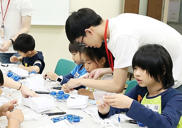 台科大資管系碩一學生胡宇謙擔任課程老師教小朋友組裝動力車。圖／台科大提供