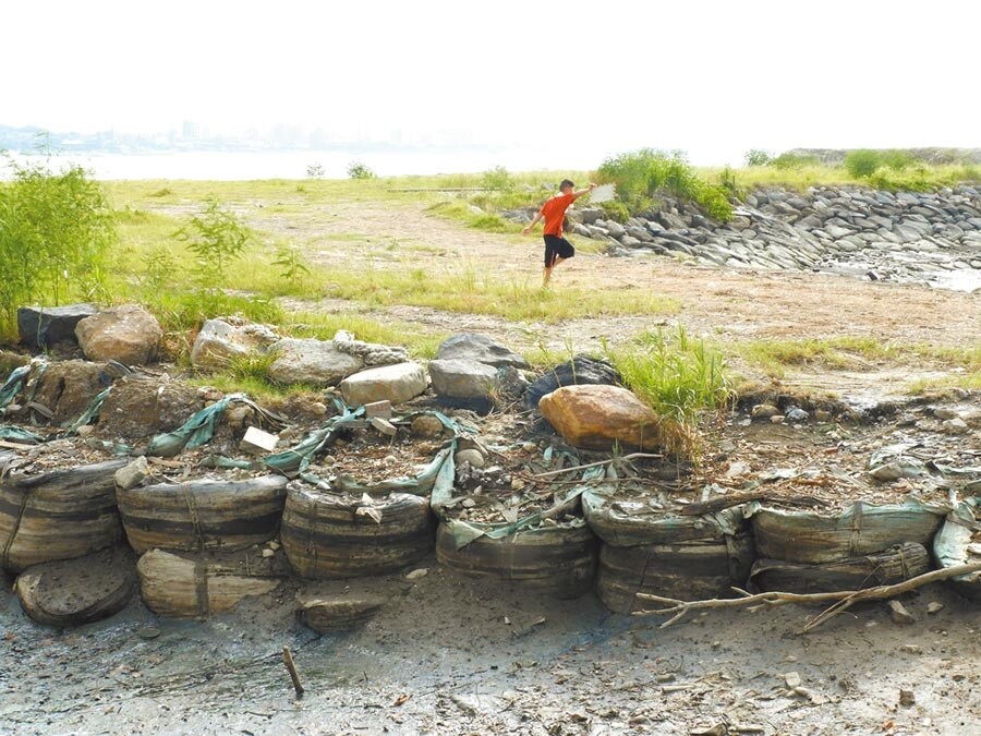 淡水老街「金色水岸」可欣賞淡水河口風光，也能遠眺觀音山，但離岸上滿是發黑太空包，一旁庄仔內溝更是傳出陣陣惡臭，新北市議員鄭宇恩日前會勘要求改善，水利局承諾將太空包改為砌石護岸，並加強庄子內清淤工程，全力改善水質問題。（戴上容翻攝）