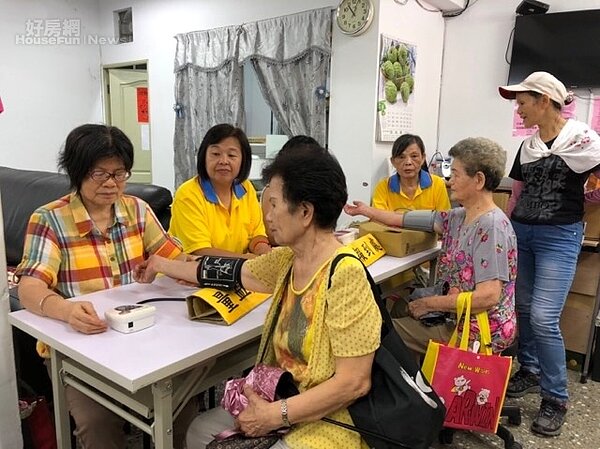 永慶土城明德店協助日新里舉辦銀髮共餐活動,提供免費量血壓為長者健康把關。(永慶房屋提供)