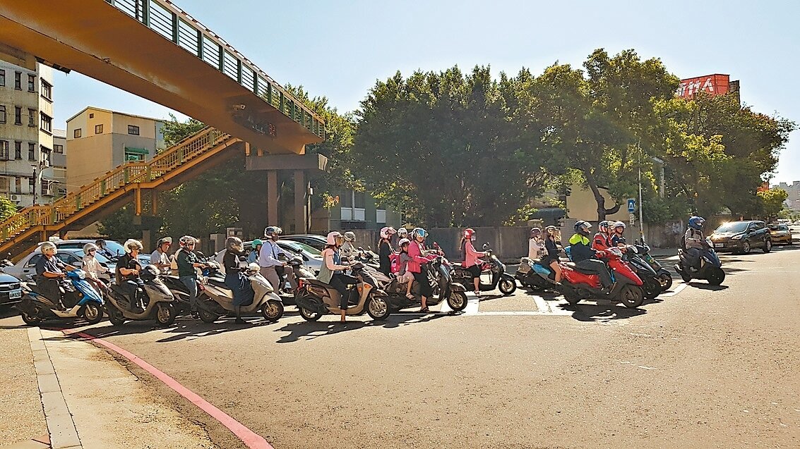 新竹市東光路通勤尖峰時段機車流量大，路口停等與待轉區根本「塞」不下，許多機車停到光復路邊緣。 記者黃瑞典／攝影