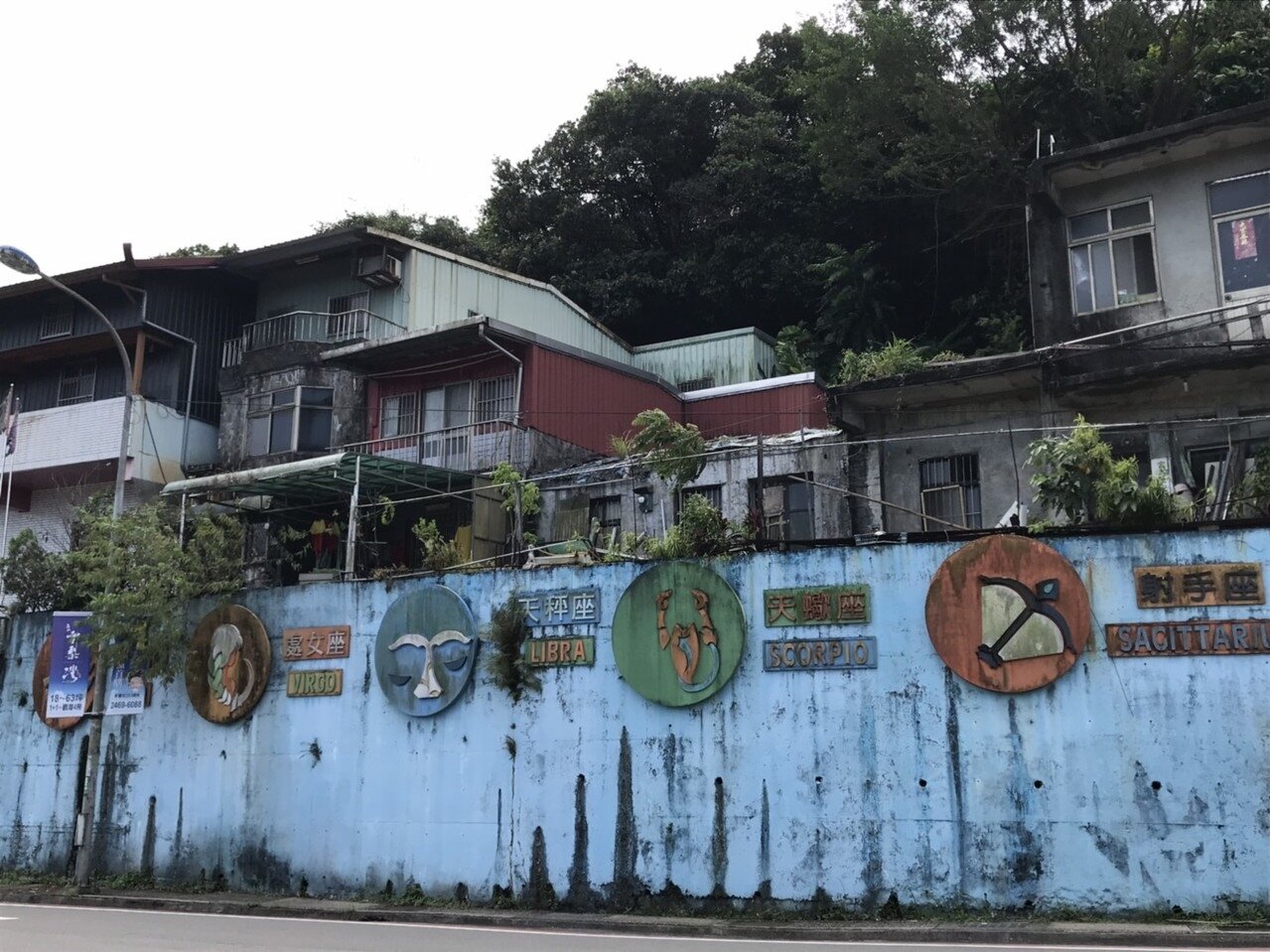 基隆市不少擋土牆長久以來多會彩繪或設置海洋生物等的造型物美化,但因日曬雨淋多破舊不堪,長滿雜草青苔。記者游明煌/攝影