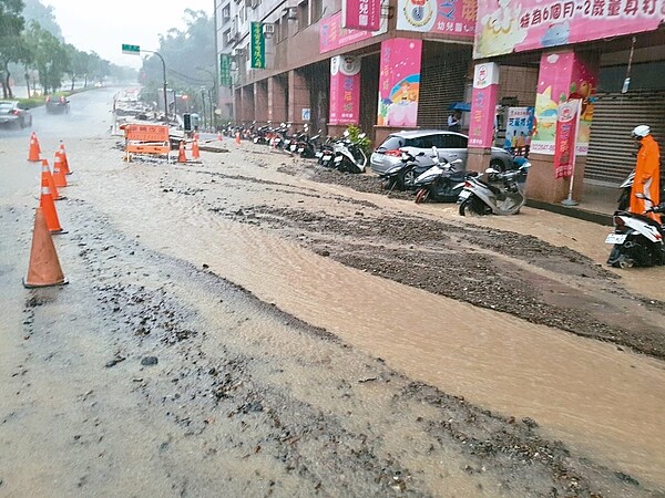 汐止區新台五路二段因連兩天豪雨侵襲，造成砂石堆積、排水不良，機車半個輪胎泡水中。 記者江婉儀／攝影