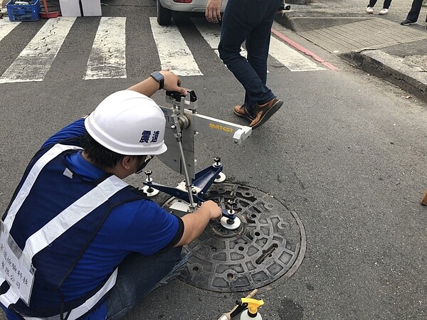 高市府工務局最近在中正路與河東路口選擇部分人孔蓋及橋梁伸縮縫試辦噴灑「防滑塗裝材料」，藉以了解目前業界新材料的耐用性及實用性。圖／高雄市工務局提供