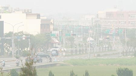 中部霧霾來襲！彰化縣未在中央山脈背風面，空氣無法擴散，造成汙染物累積，彰化縣空品監測線西站，上午飆上全國空品最差，鄰近彰濱工業區進出車輛入墜五里霧，一片灰濛濛，能見度極低。（吳敏菁攝）