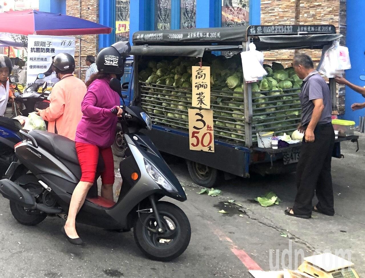雲林縣菜農載一整車高麗菜，在嘉義市共和市場叫賣， 3顆重約5至6斤賣50元，吸引婆婆媽媽搶購。記者魯永明／攝影