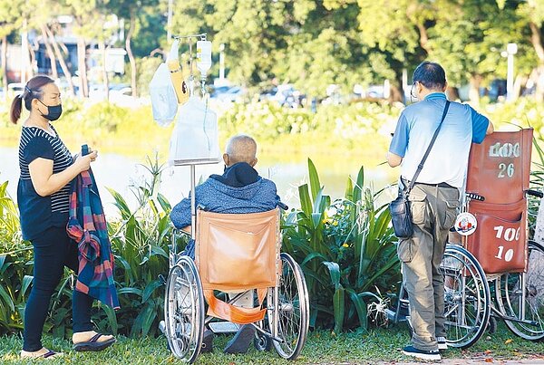 增訂長照扣除額，每人每年可定額扣除新台幣12萬元，並訂排富條款為稅率20%以上，明年報稅時即可適用，圖為黃昏時刻，家屬推著病患至公園散心。（陳怡誠攝）