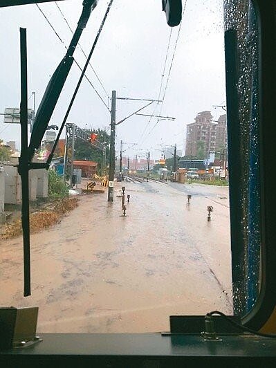 鶯歌尖山埔路平交道雙向鐵軌都因大雨積水,以致一列從桃園開鶯歌的台鐵退回桃園。(圖/台鐵提供)