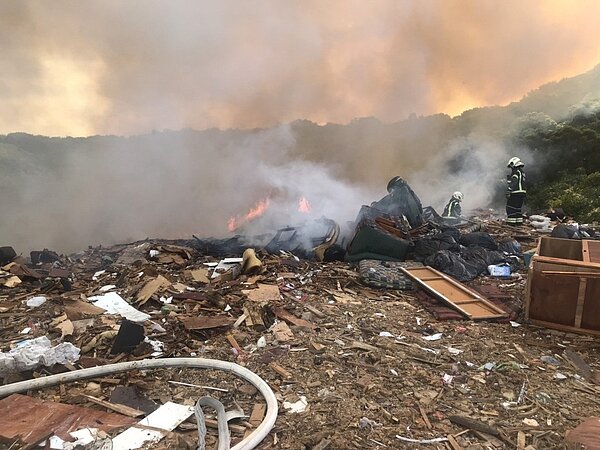 桃園市虎頭山垃圾掩埋場突然悶燒起火,濃煙臭味飄出,桃園市消防員全力灌救減滅火。記者曾增勳/翻攝