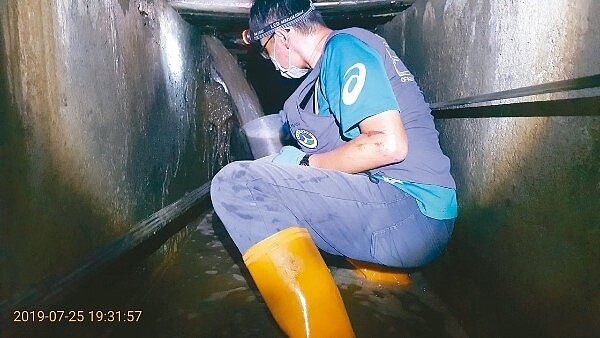 台南市環保局稽查員追查偷排電鍍廢水，變身「忍者龜」鑽入下水道採證。 圖／環保局提供