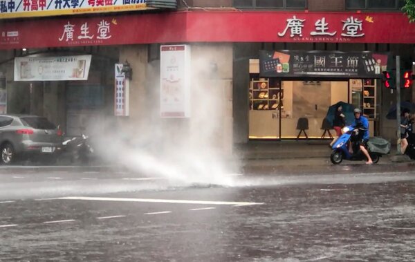 台中市區大雨，南屯區公益路、河南路口的人孔蓋，被宣洩不及的大水噴得往上衝，現場險象環生。記者洪敬浤／翻攝