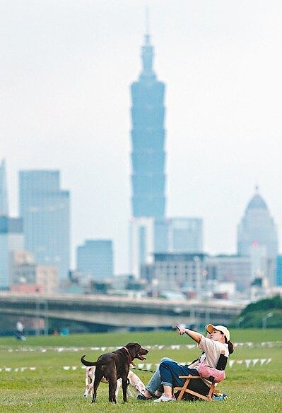 冷氣團報到,今起全台氣溫明顯下降,民眾昨天把握變天前的好天氣,在河濱公園草坪上享受愜意的假日時光。 記者侯永全/攝影