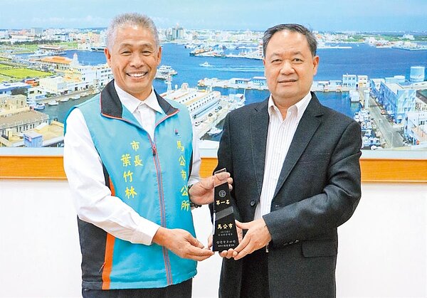 澎湖縣馬公市蟬聯節電鄉市第1名,台電處長陳慶平(右)頒贈獎杯慶賀馬公市長葉竹林(左)。(陳可文攝)