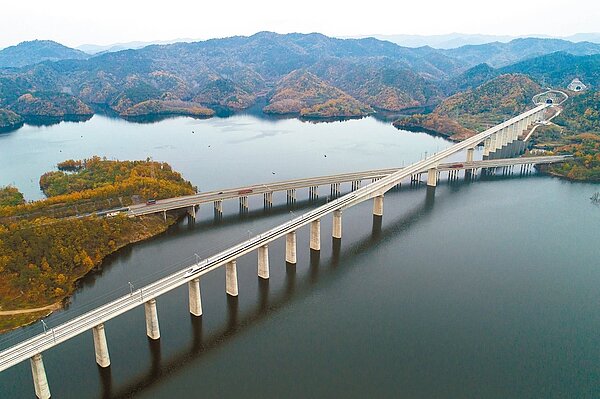 武漢至十堰高鐵開通運營,將大大挹注貧困縣的經濟發展。圖為漢十高鐵試運行期間,一趟列車從丹江口水庫上駛過。圖/截自新華社
