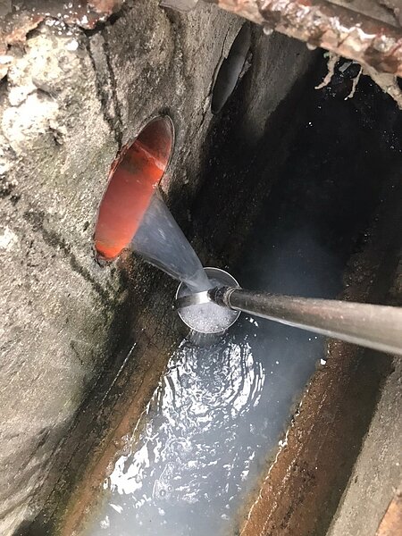 稽查人員在食品業排放口採集水樣送驗。圖/高雄市環保局提供