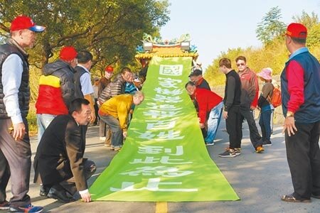 50多名西螺鄉親拉巨幅綠色布條喊口號「我們堅絕反對,國家機器追殺百姓,蔡英文政府到此為止」。(周麗蘭攝)