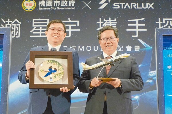 桃園市長鄭文燦（右）與星宇航空董事長張國煒（左）簽下MOU後，雙方交換紀念品。（甘嘉雯攝）