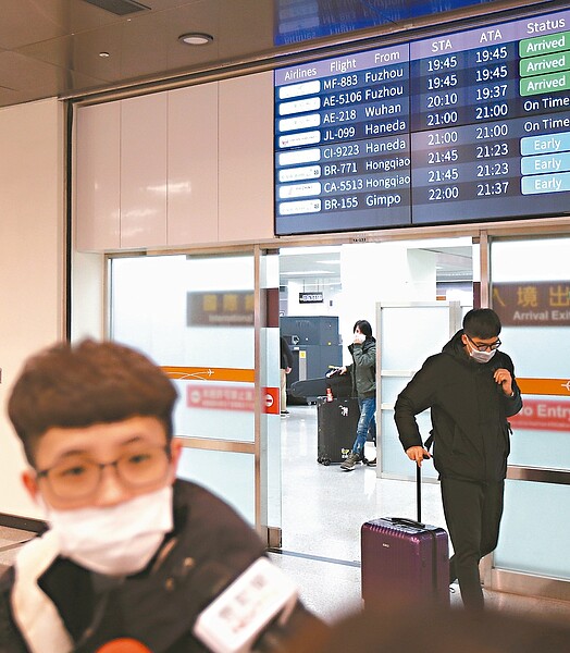 華信航空班機昨晚自武漢飛抵松山機場，很多乘客都戴上口罩。 記者蘇健忠／攝影