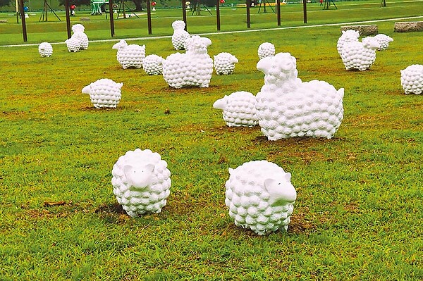 新北大都會公園幸福水漾園區即日起至4月展出藝術家蔡坤霖作品《詩步領羊》,60隻綿羊戶外藝術在草地上,看上去既悠閒又療癒。(新北市文化局提供/譚宇哲新北傳真)