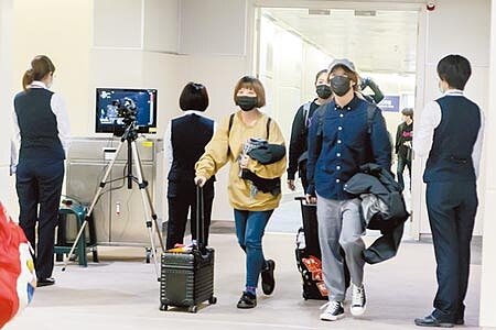 檢疫人員2日登上疫情傳出後的首架從武漢飛抵桃園機場直航班機，執行檢疫及宣導工作，同時也在空橋門口架設機動型紅外線檢測儀，下機旅客一出登機門後，就直接做發燒篩檢檢疫作業，雙管齊下防疫。（本報資料照片） 