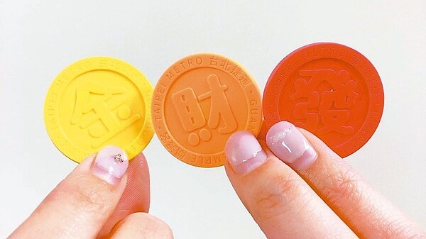 3款圓形票卡分別印有紅色的「發」字、橘色「財」字，和光輝亮眼的黃色「金」字。 圖／台北捷運公司提供