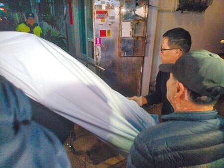 林嫌12日晚間被發現陳屍在基隆市七堵一處舊公寓,遺體由葬儀社人員運下樓。圖/記者許家寧攝影