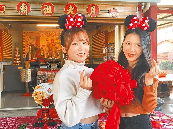 盧衣綸(左)、陳巧芃(右)到大福興宮月老祖廟求桃花良緣。(廖素慧攝)