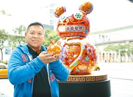 雕塑藝術家洪易為新光三越全新創作「鼠來寶」,位在台北信義新天地A8 1樓北大門,背面也可觀賞,且有恭喜發財賀詞;他手拿著「財鼠廣進橘撲滿」,26、27日貴賓卡、APP會員當日當店單卡累滿3000元限量兌換。圖/粘耿豪攝