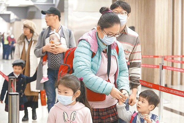 大年初二,民眾南來北往回鄉團聚,搭機抵達松山機場的旅客,多半都戴上口罩自主防疫。(張鎧乙攝)