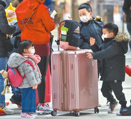 春節連假結束遇寒流發威，台北車站內出現返回工作崗位的人潮，跟在大人身旁的3位小朋友，穿著厚重的外套保暖。（劉宗龍攝）