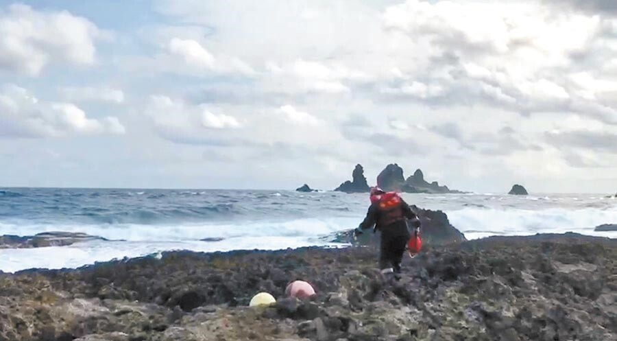 台東縣蘭嶼鄉29日傳出膠筏翻覆意外,3人落海,其中1人命大自行游上岸,另外2人失蹤,海巡人員沿著岸際搜尋。(海巡提供/楊漢聲台東傳真)