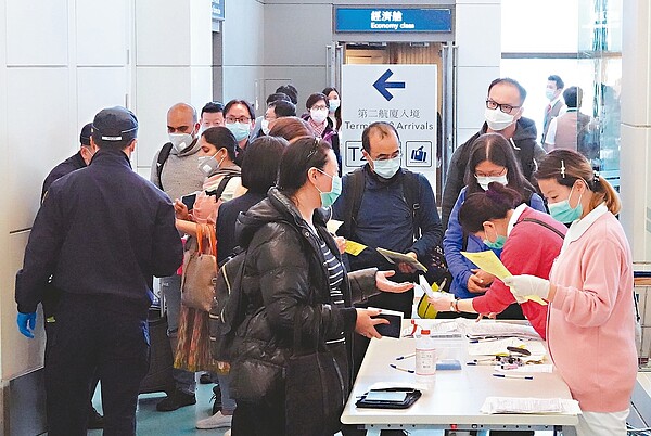 中央流行疫情指揮中心宣布,港澳人士即日起入境後需居家檢疫十四天不能外出,桃園機場昨天下午來自香港的班機抵達時,支援的護士與保警在閘口一一要求入境旅客仔細填寫健康聲明卡,一度引起旅客抱怨。 記者鄭超文/攝影